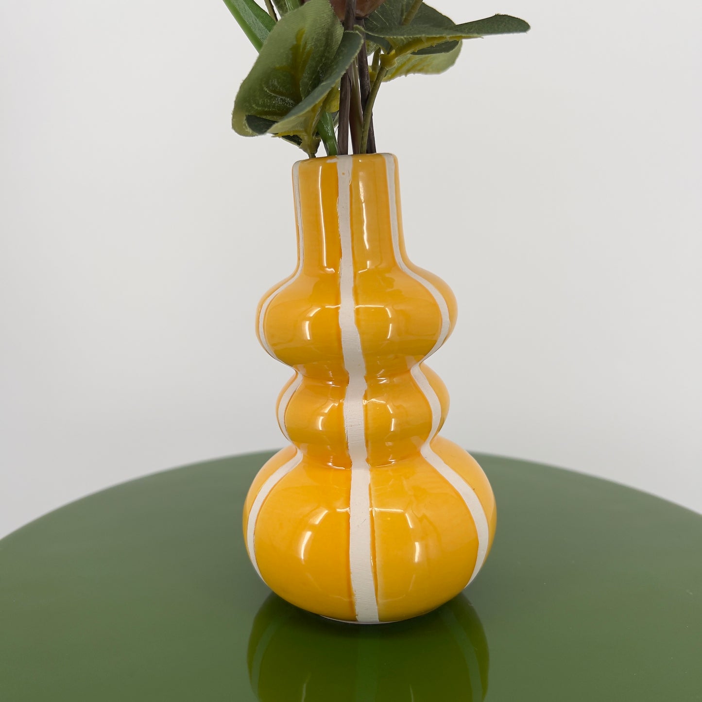 Geel vaasje met witte streep gevuld met diverse bloemen, 36cm